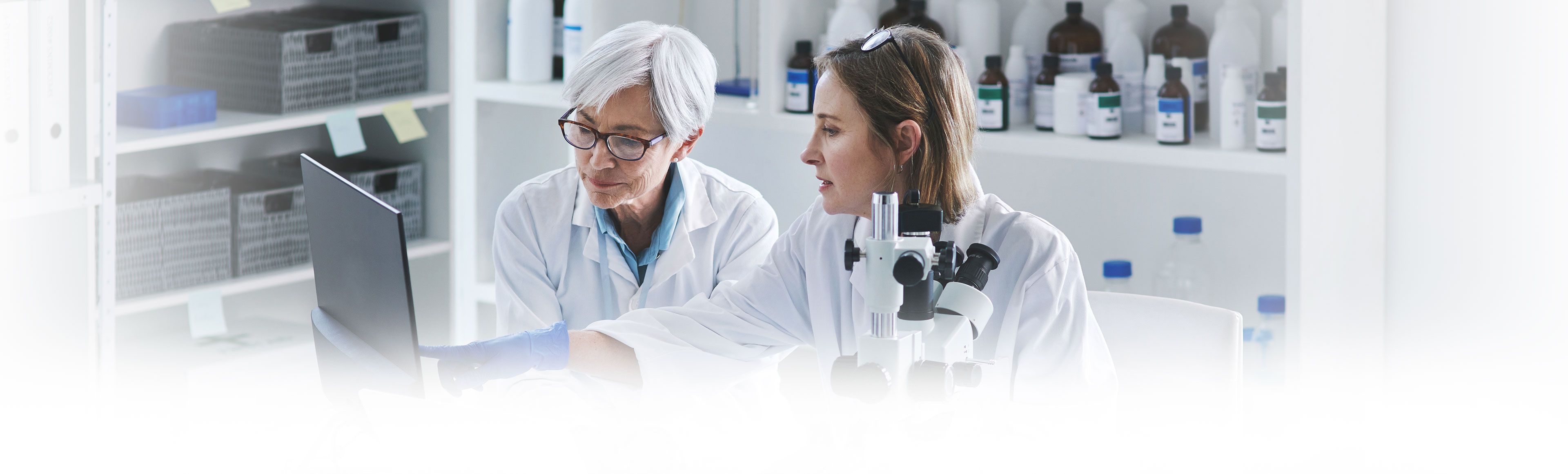 Two women viewing a computer in a lab