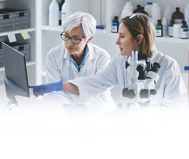 Two women viewing a computer in a lab